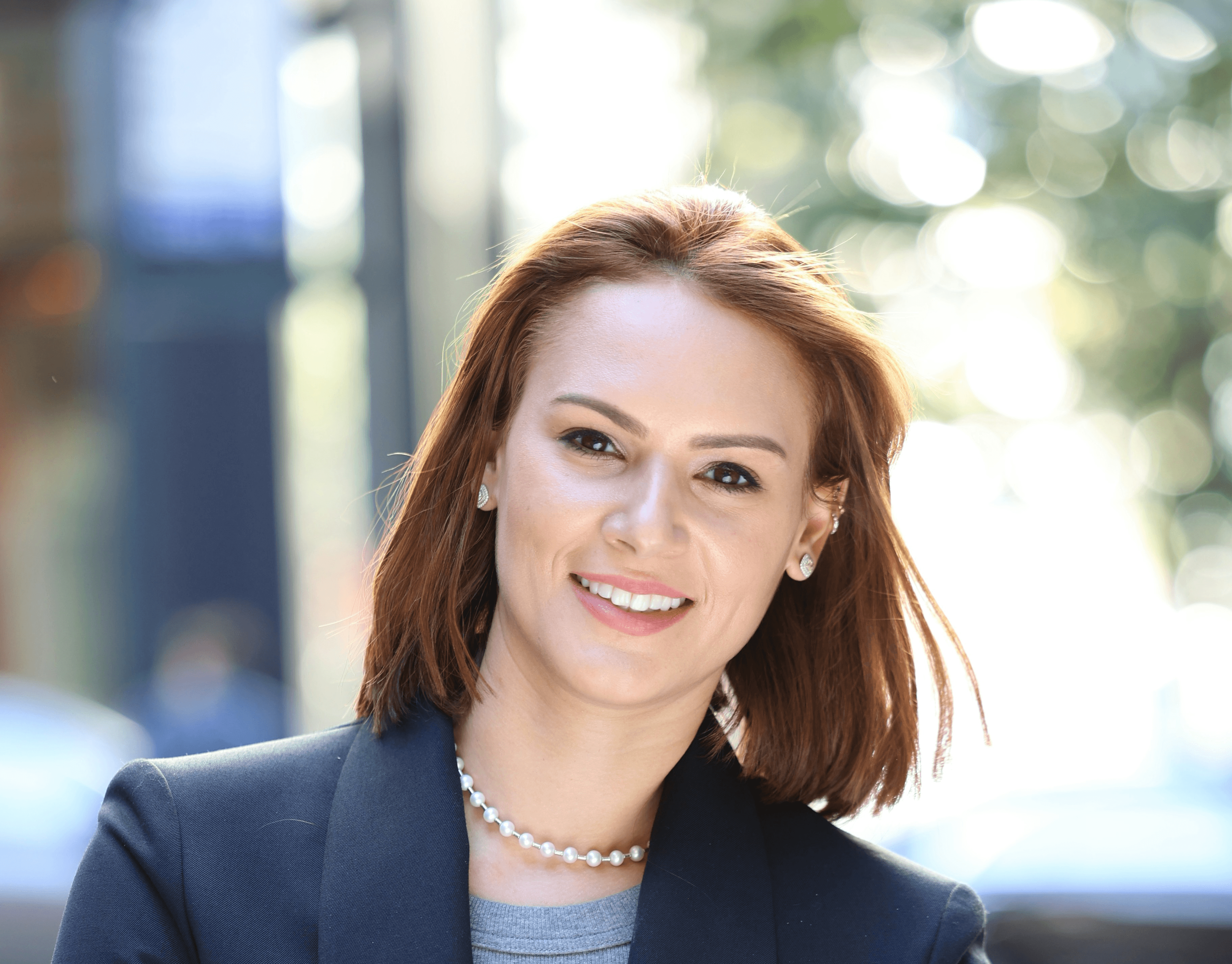 a woman with her arms crossed standing in front of a building