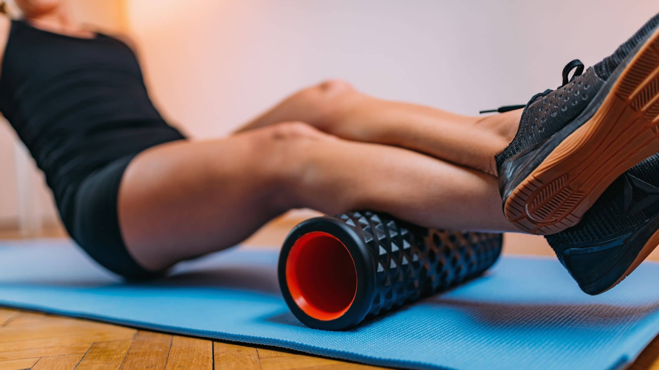 a woman foam rolling her calves after a tough workout