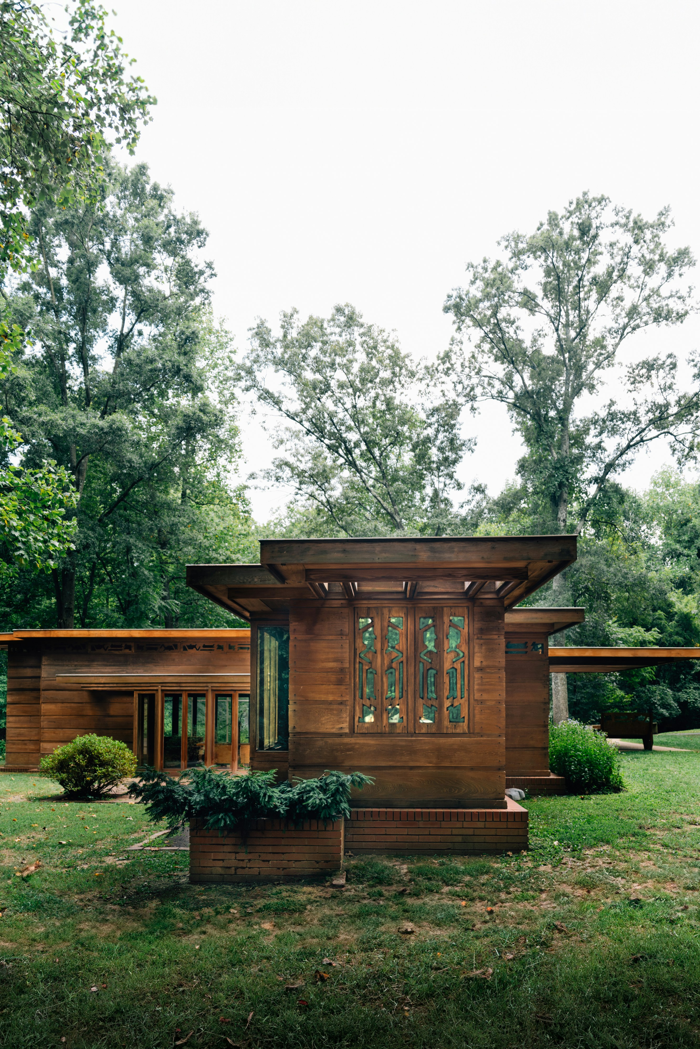 A small wooden structure sitting in the middle of a lush green field