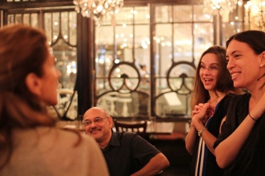 people smiling and looking at each other in a restaurant