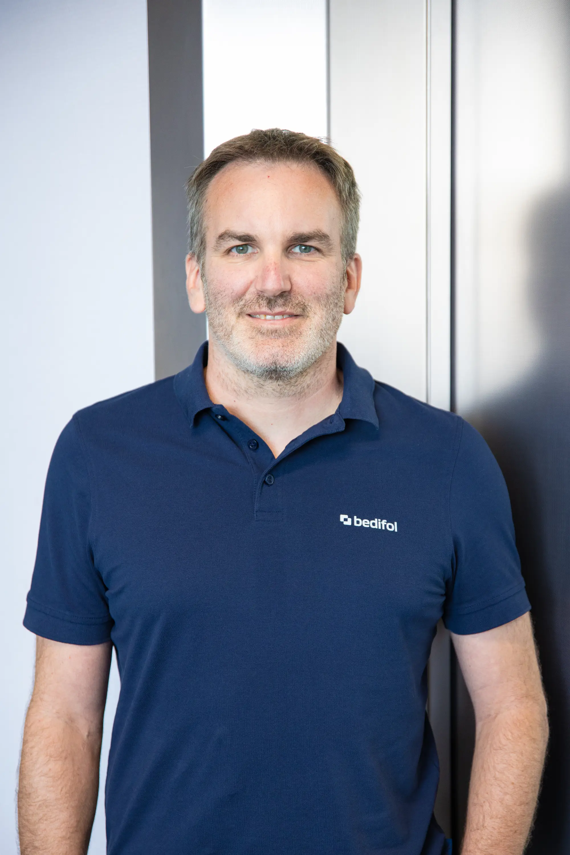 Dominik Oriwall wearing a dark blue Bedifol polo shirt.