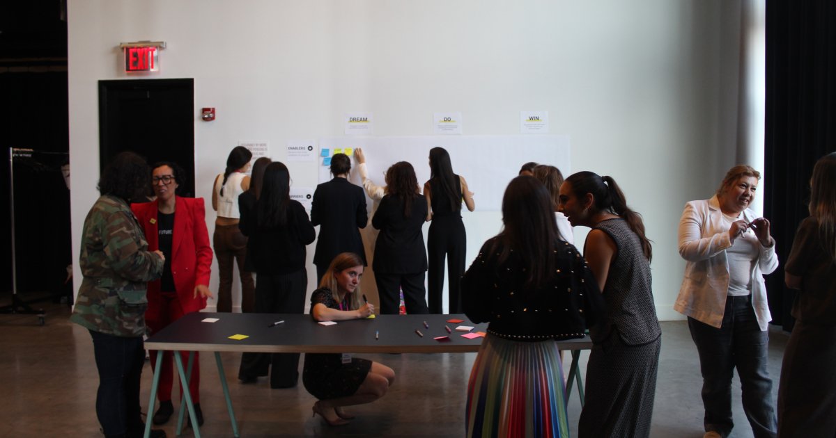 Group of people putting sticky notes on a white wall