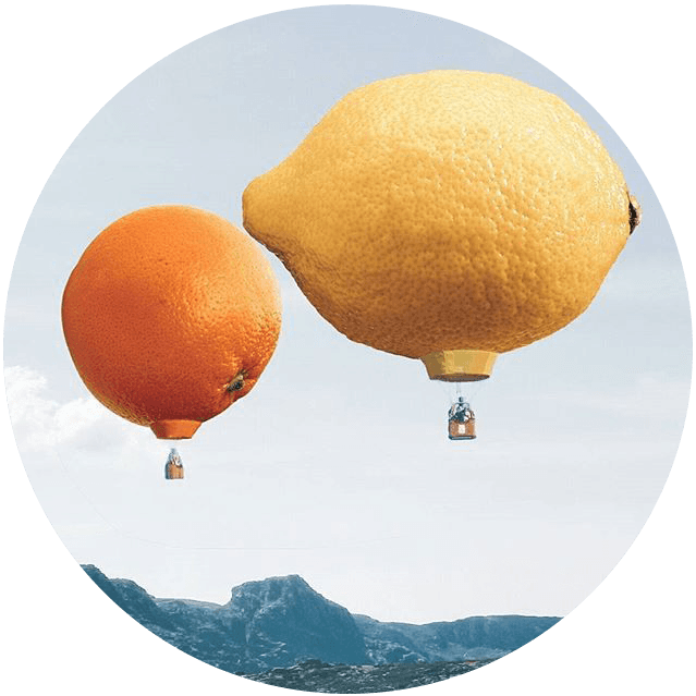A large orange being lifted above a colorful landscape.