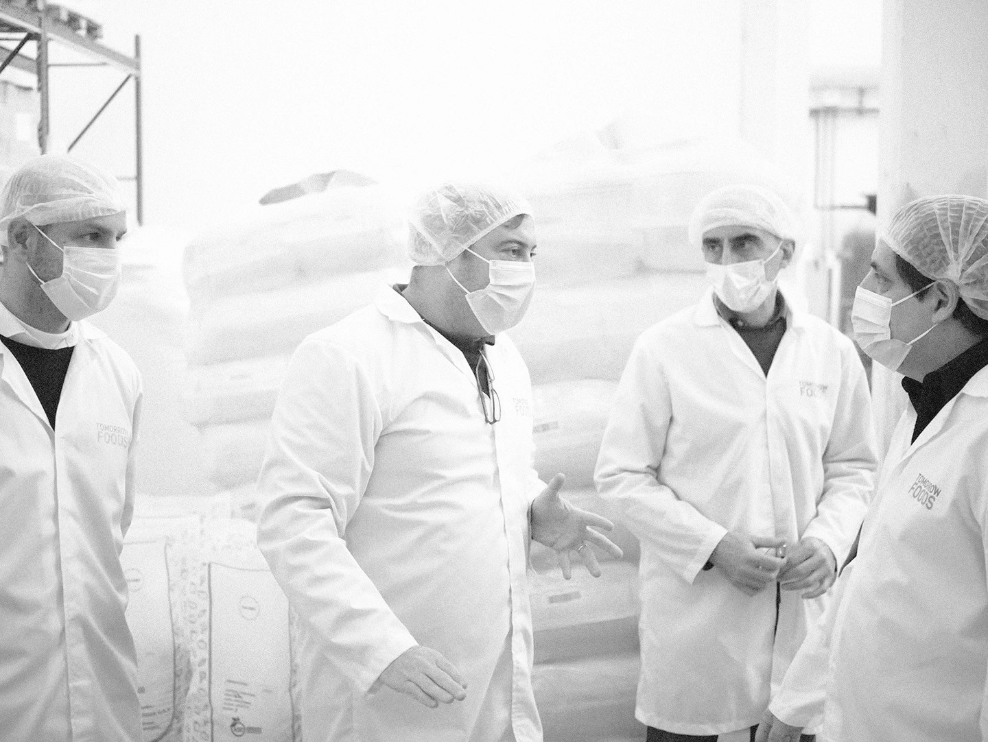 Team in lab coats working with equipment in a clean, organized laboratory.