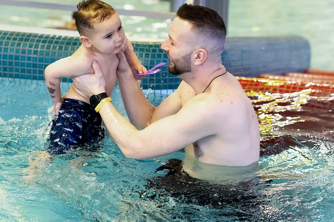 otec s ditetem hrajici si v bazenu