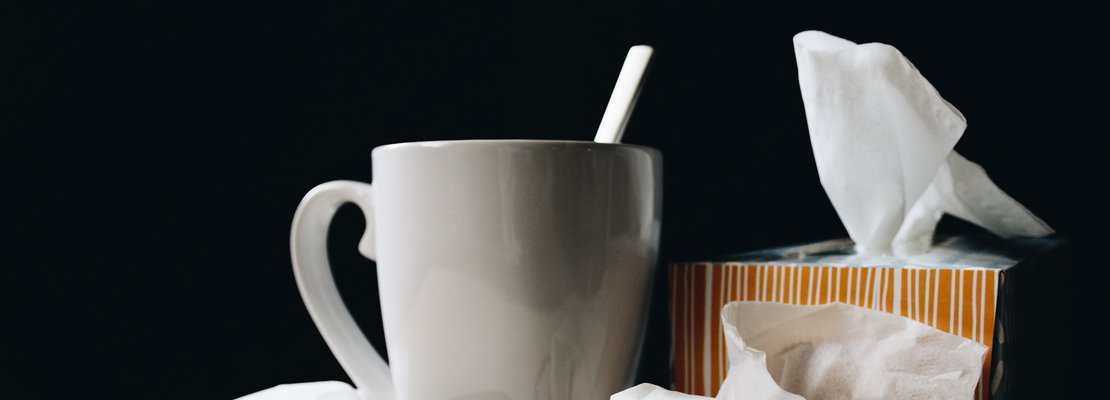 a cup of coffee beside a tissue box