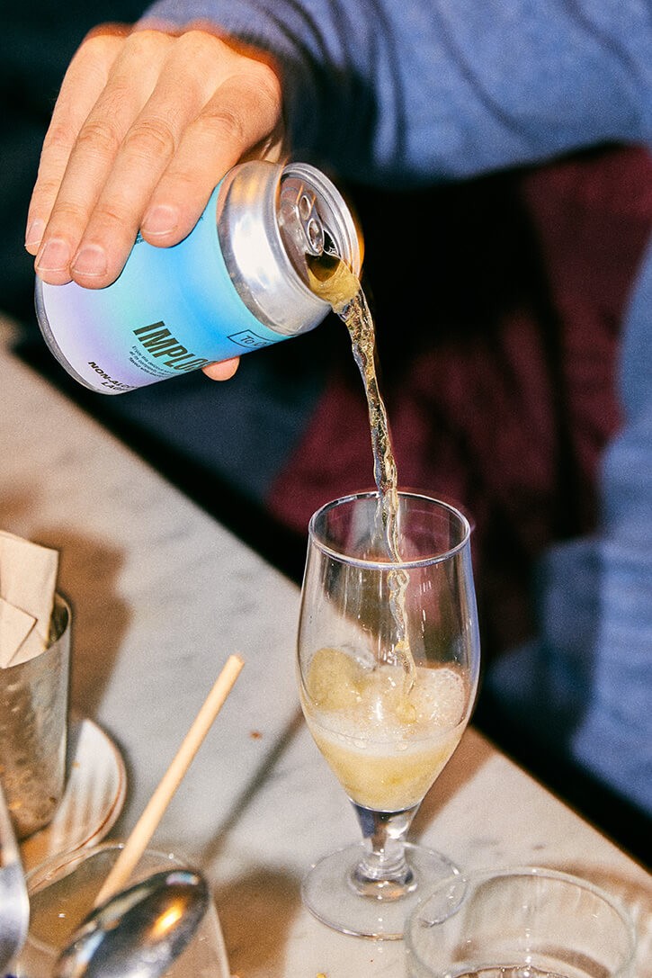 A person pouring a beer into a glass