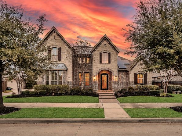 A house with the sunset behind, showing the work of an arlington roofer