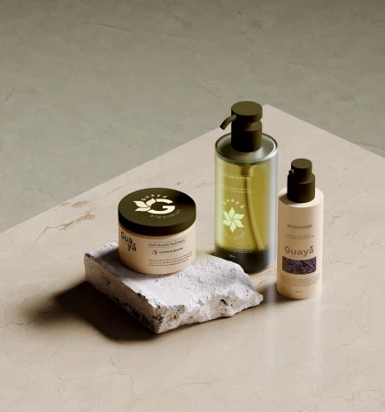 Vários produtos de cuidados pessoais dispostos sob uma mesa de mármore, simulando as embalagens da Guayá.
