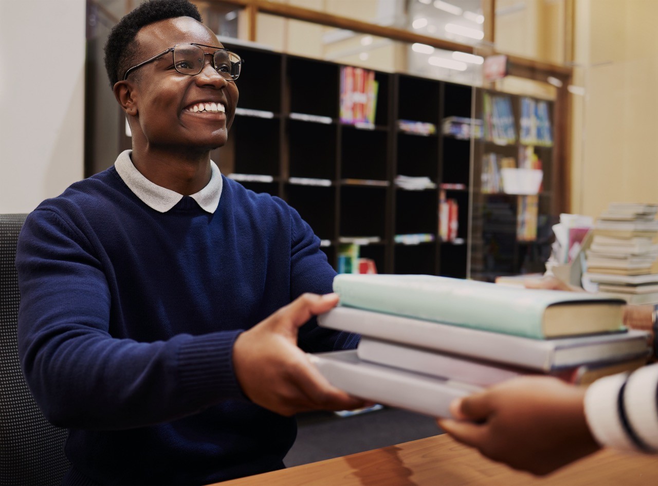 Man in library holding books