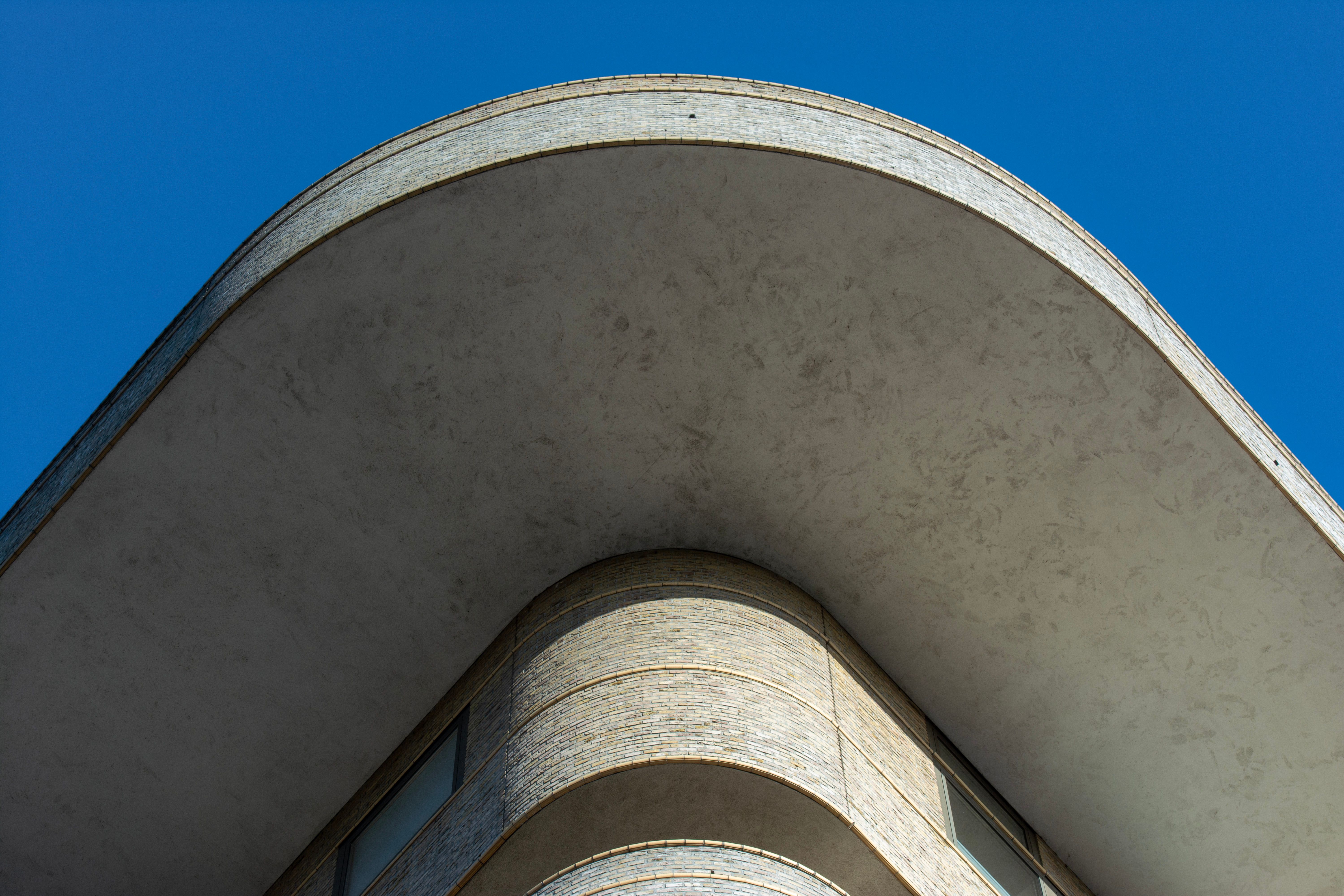 A striking image of a modern architectural building with curved lines against a vivid blue sky.