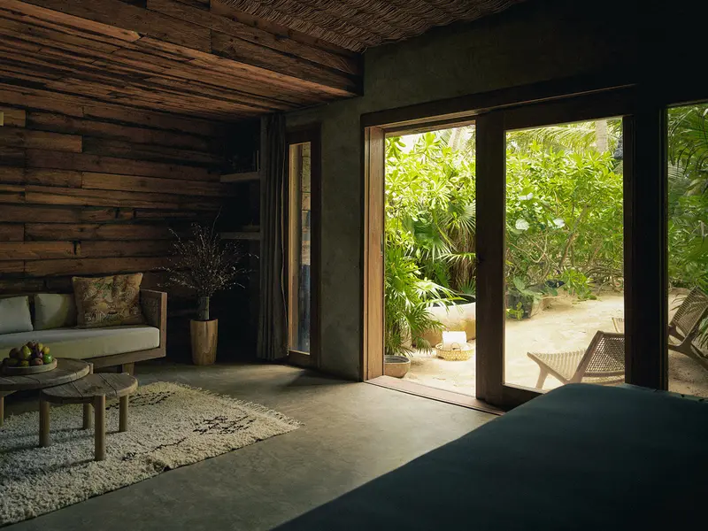 Agua Suite at Be Tulum with large windows, tree views, seating area, and carpet.