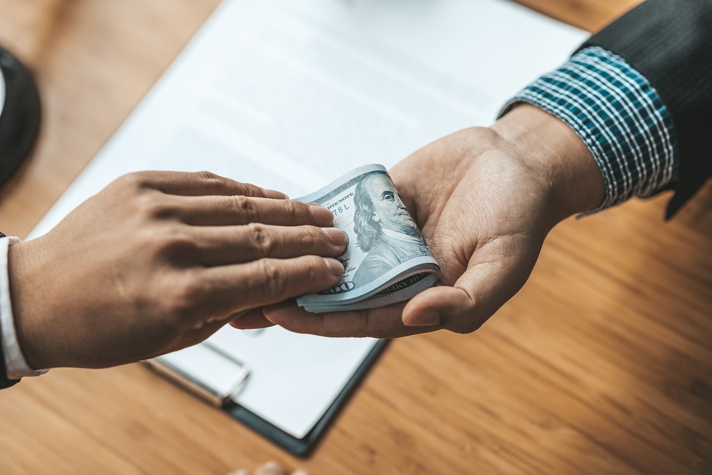man standing in front of people sitting beside table with laptop computers