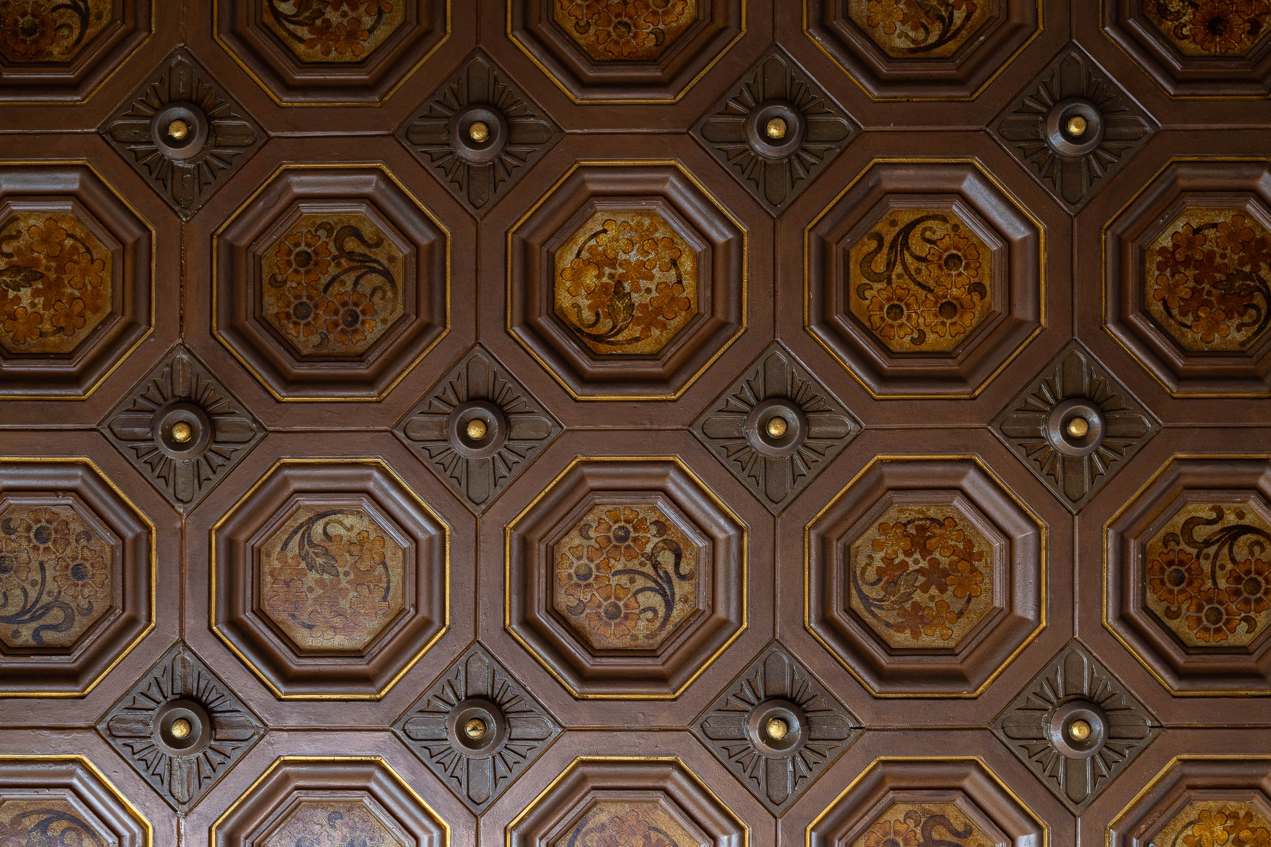 Ornate wooden ceiling with floral octagonal patterns and embossed details.
