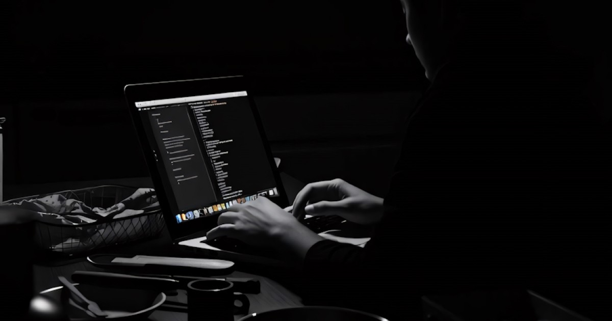 Person working on Framer template in dark room with code editor open on MacBook
