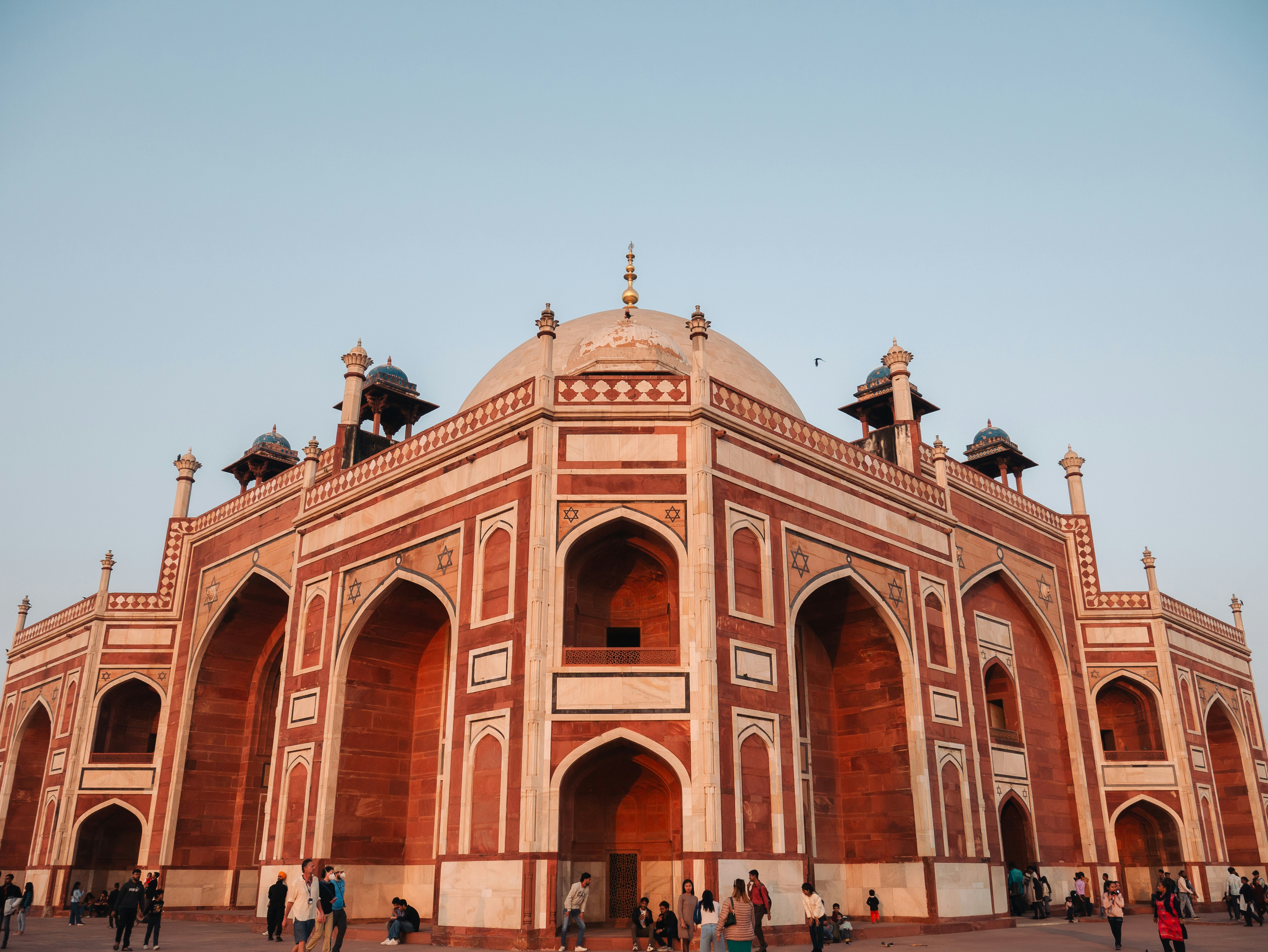 A large red and white building with people walking around it