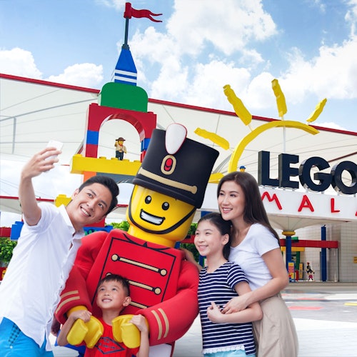A family poses for a selfie with a large LEGO toy soldier at the entrance of LEGOLAND Malaysia.