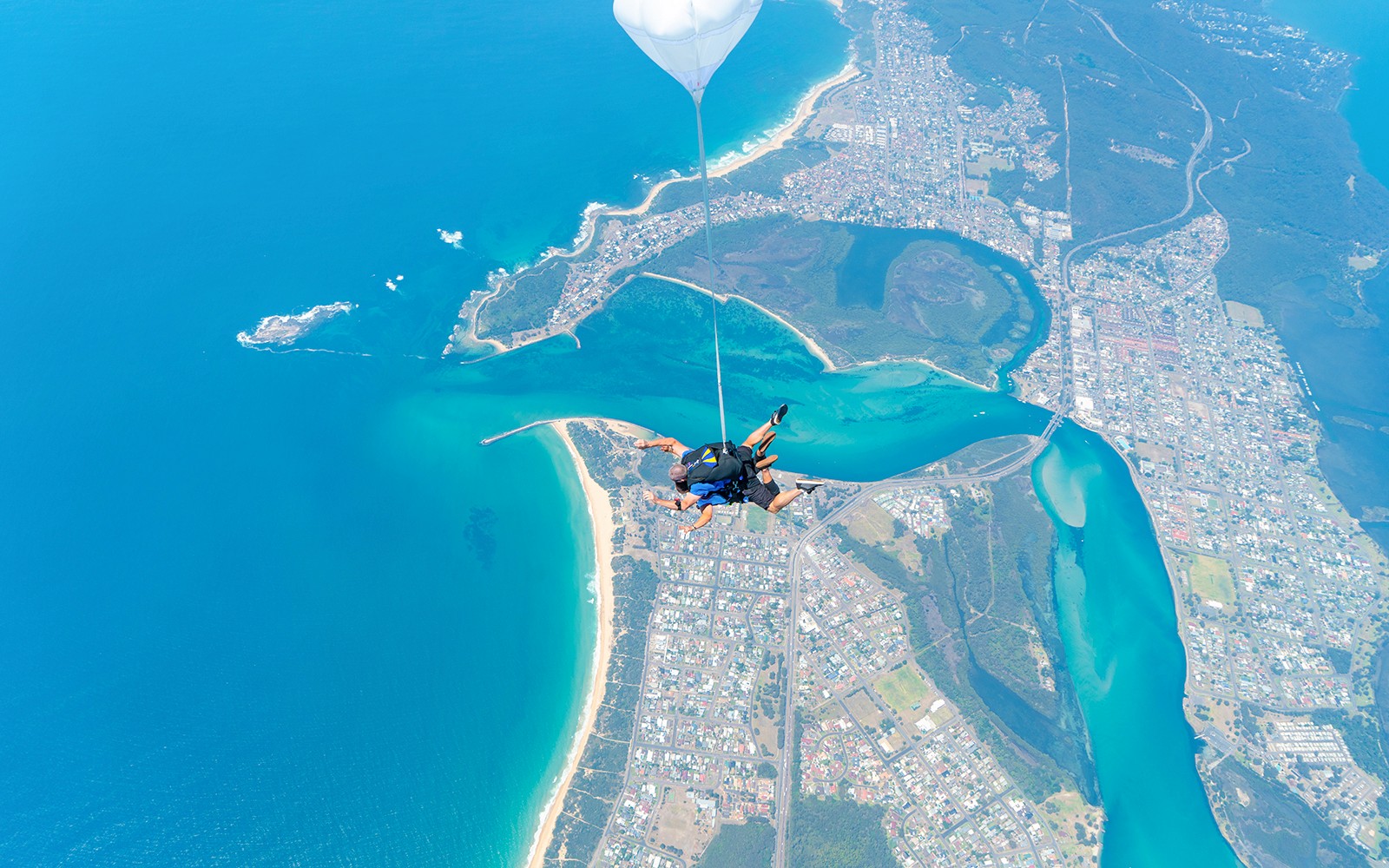 Caduta libera in tandem con paracadutista sopra Newcastle Beach, Sydney, con vista sulla costa.