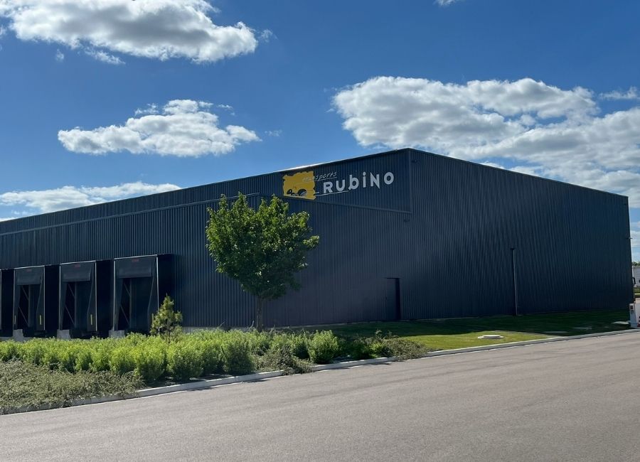 Façade d’un bâtiment industriel moderne avec bardage métallique et aire de livraison.