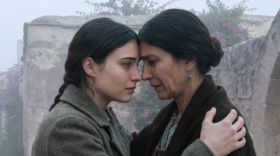 A mother and daughter, foreheads pressed together, both weeping