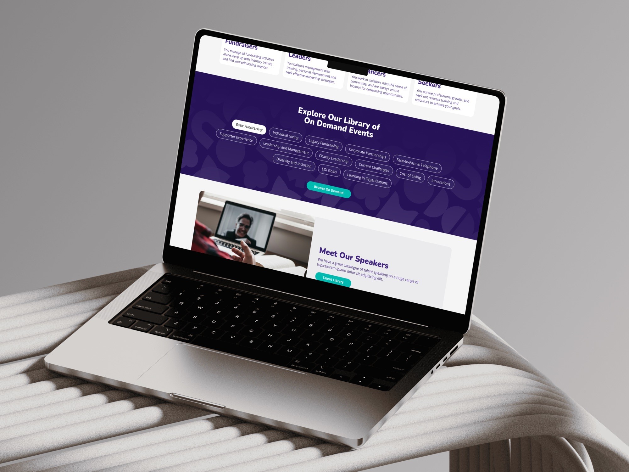 On-demand library page on a laptop, with topic tags and speaker cards