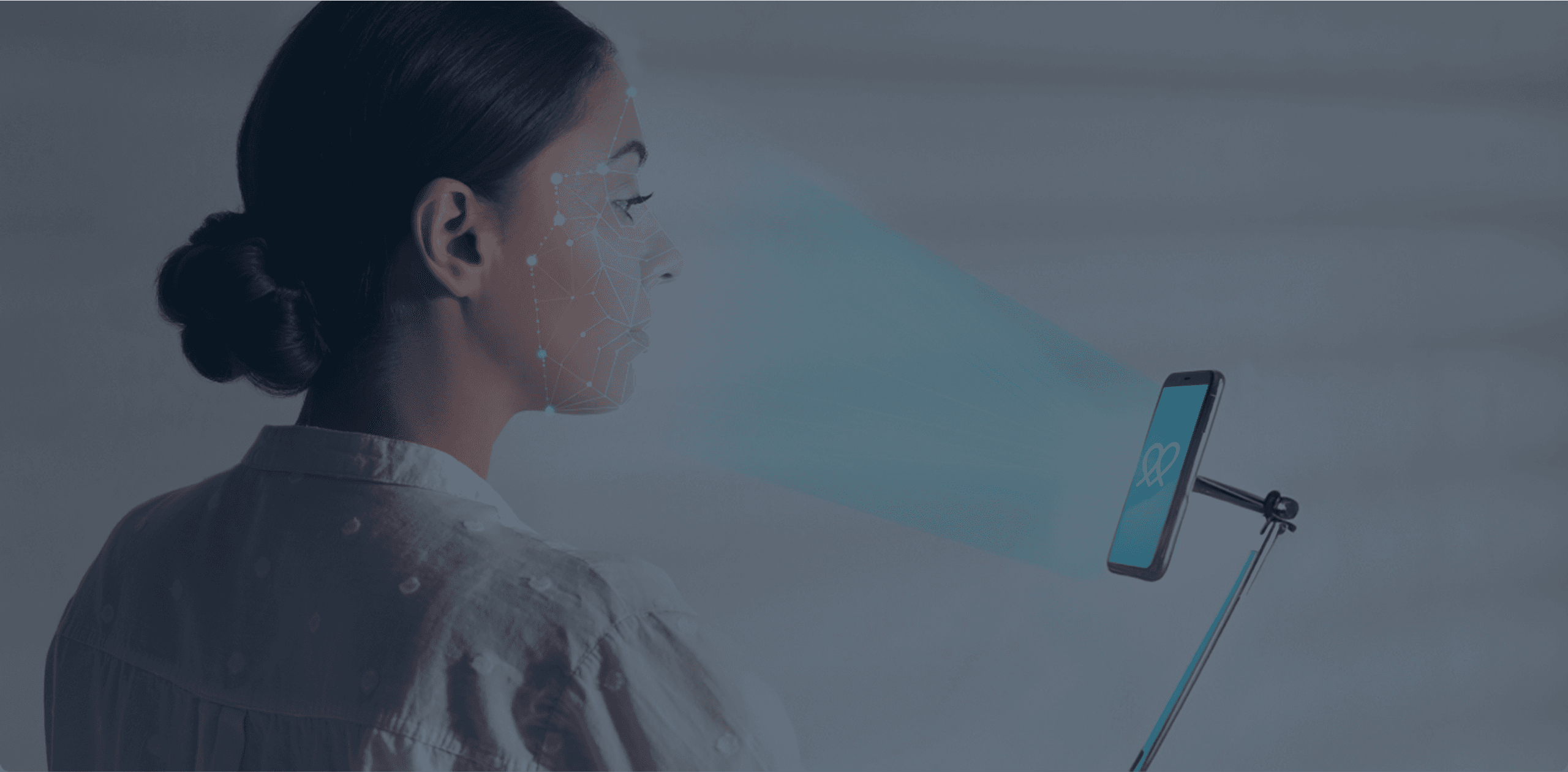 Woman faced sideways with a mobile phone on a stand with the Lifelight logo. A light coming out of the device, scanning her face. Banner.
