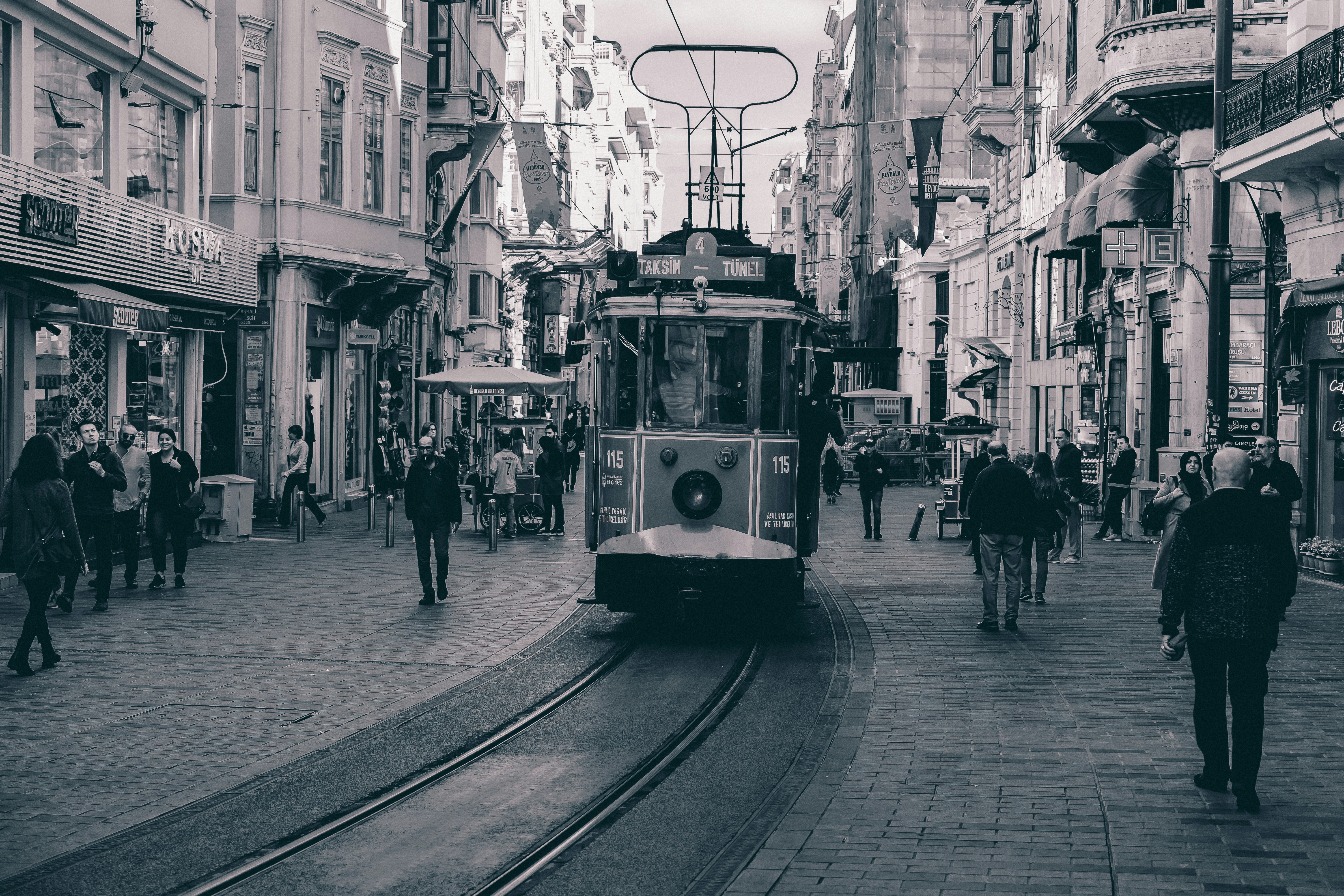 Menschen, die tagsüber auf dem Bürgersteig neben der Straßenbahn gehen