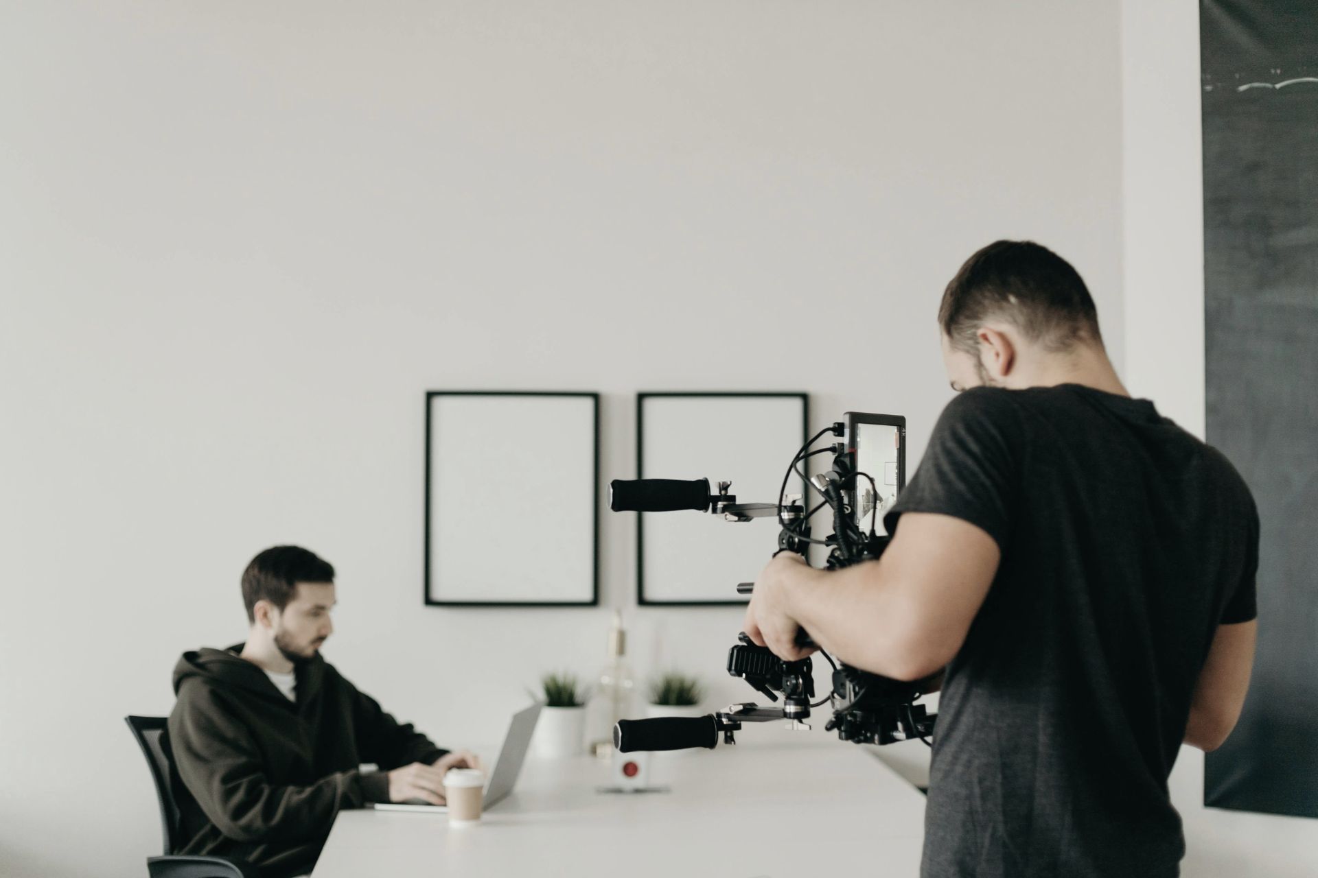 Behind-the-scenes video production of an AI software developer working at a white desk