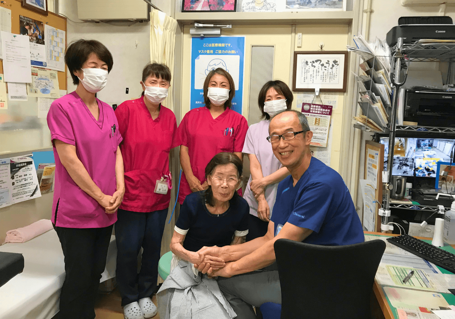 診察室で高齢女性の患者と握手する趙達来先生