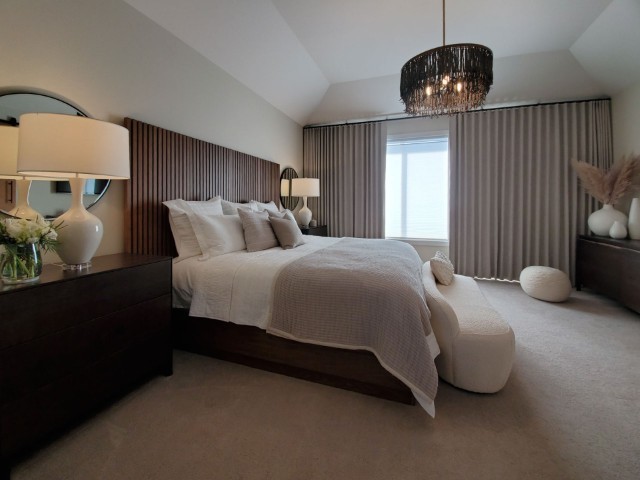 Image of Luxurious primary suite with plush furniture, elegant window coverings, and sophisticated interior design by KHD Homes.