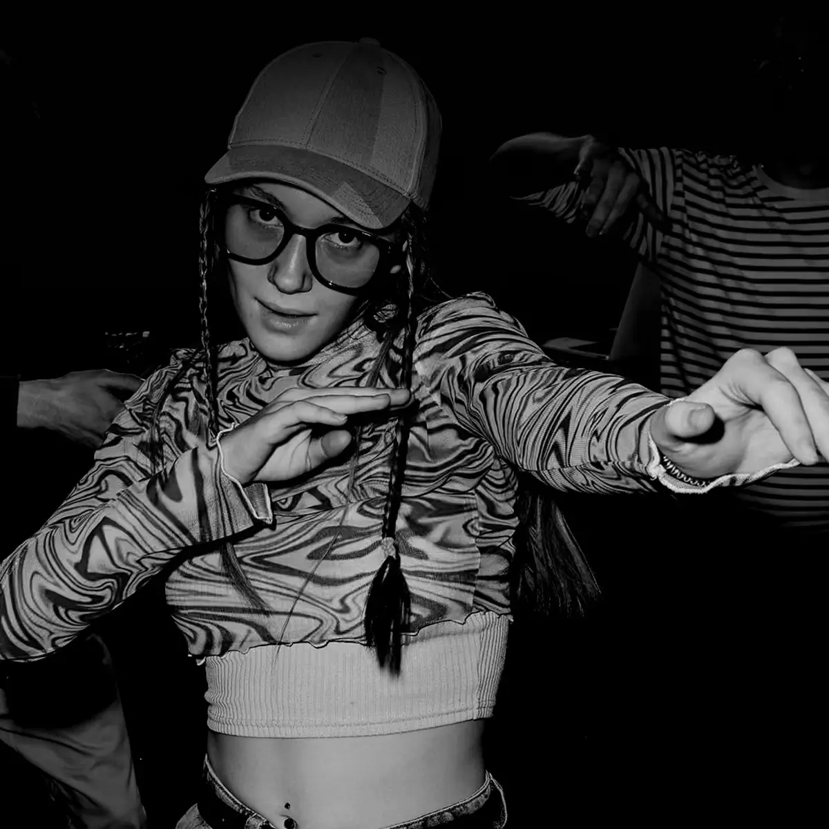 Black and white photo of a person mid-movement in a club-like setting, suggesting individuality, expression, and underground culture.