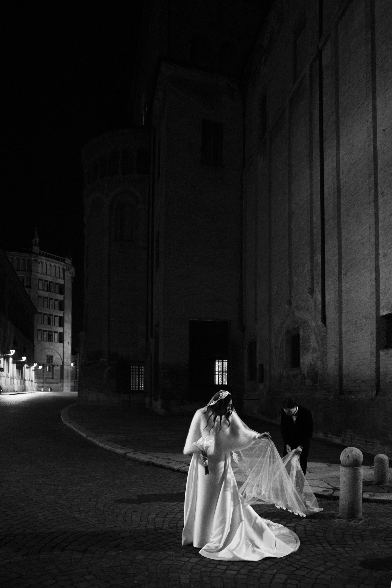 Sposa in mikado e velo nel cortile notturno del Circolo di Lettura a Parma, reportage matrimoniale in bianco e nero
