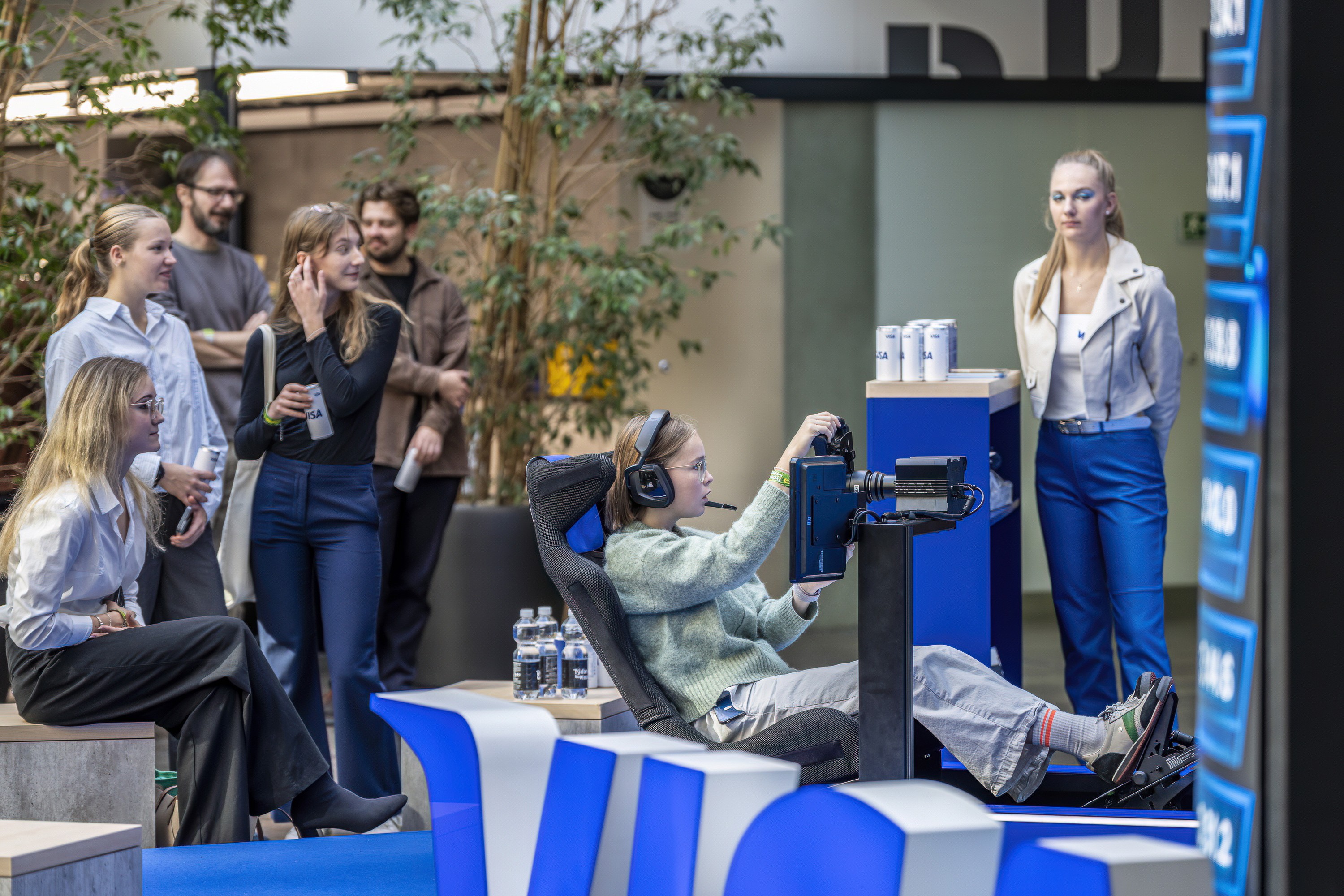 Attendees watching a live product demonstration at a conference exhibition area.