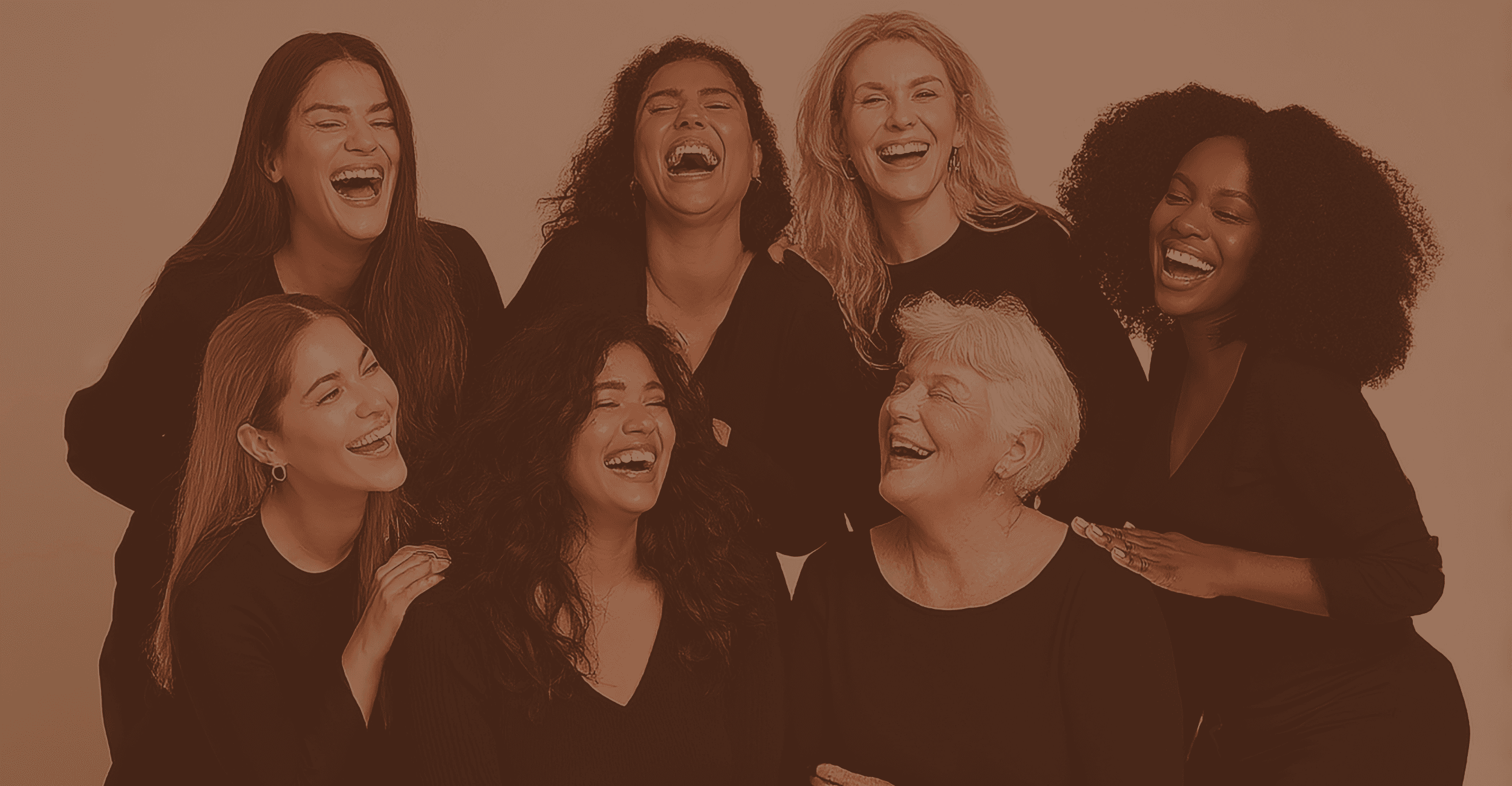 A group of women of all ages and colors wearing black clothing and smiling and laughing together
