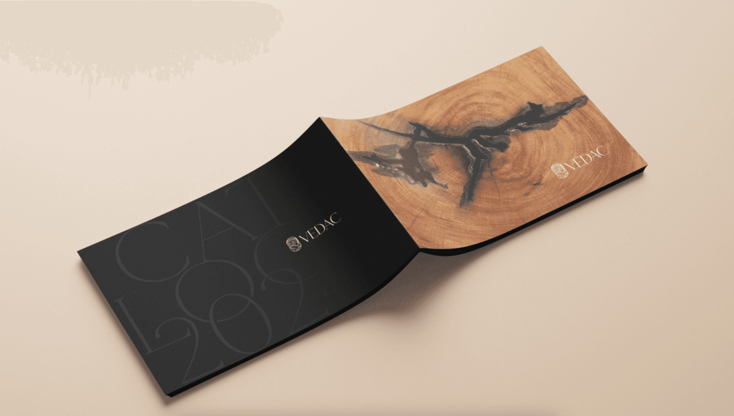 Catálogo de produtos aberto com a capa e o verso virados para cima. O verso é esta na cor preta e a capa tem uma impressão igual a madeira.