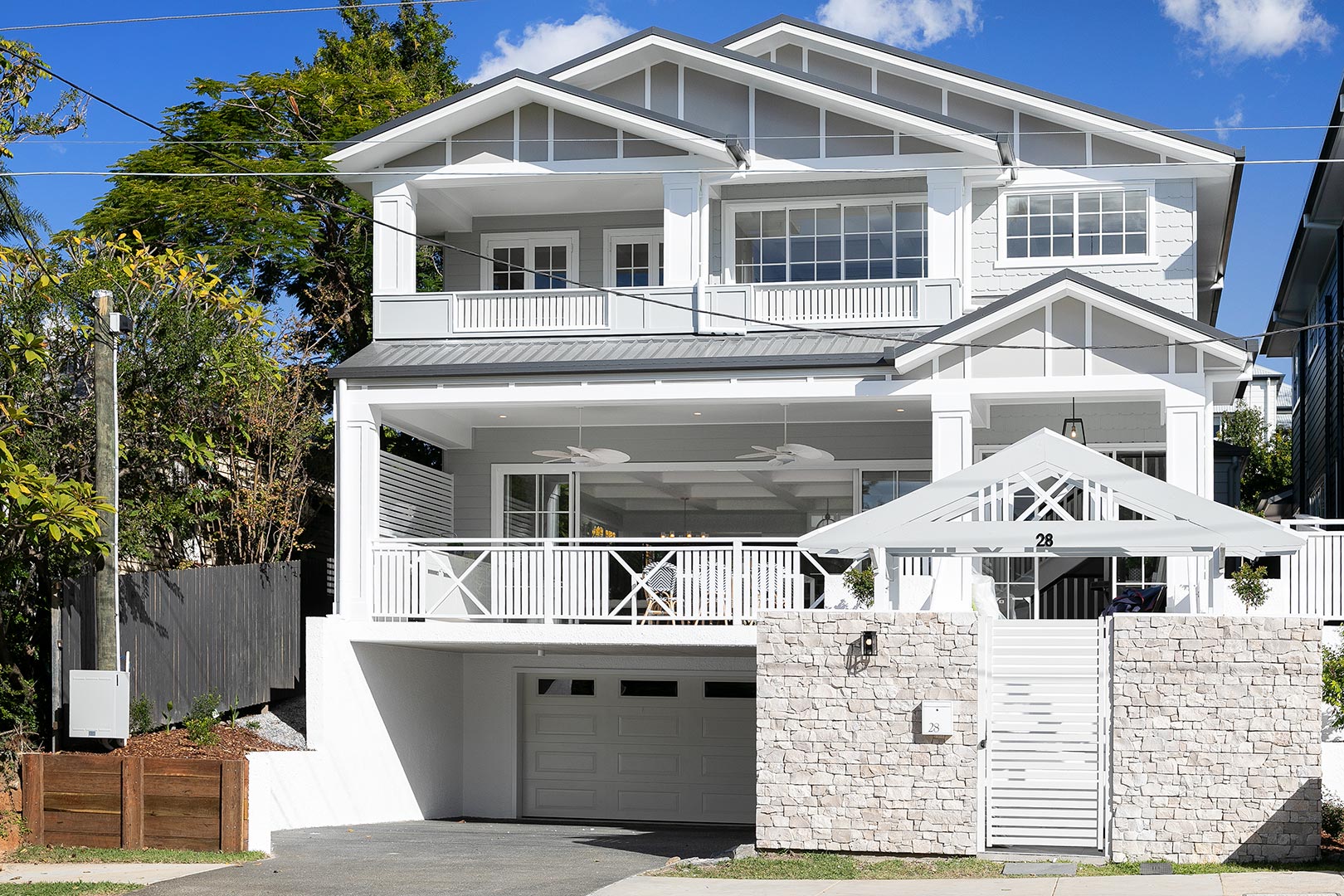 Angled street view highlighting the three-storey design of a Brisbane sloping block home