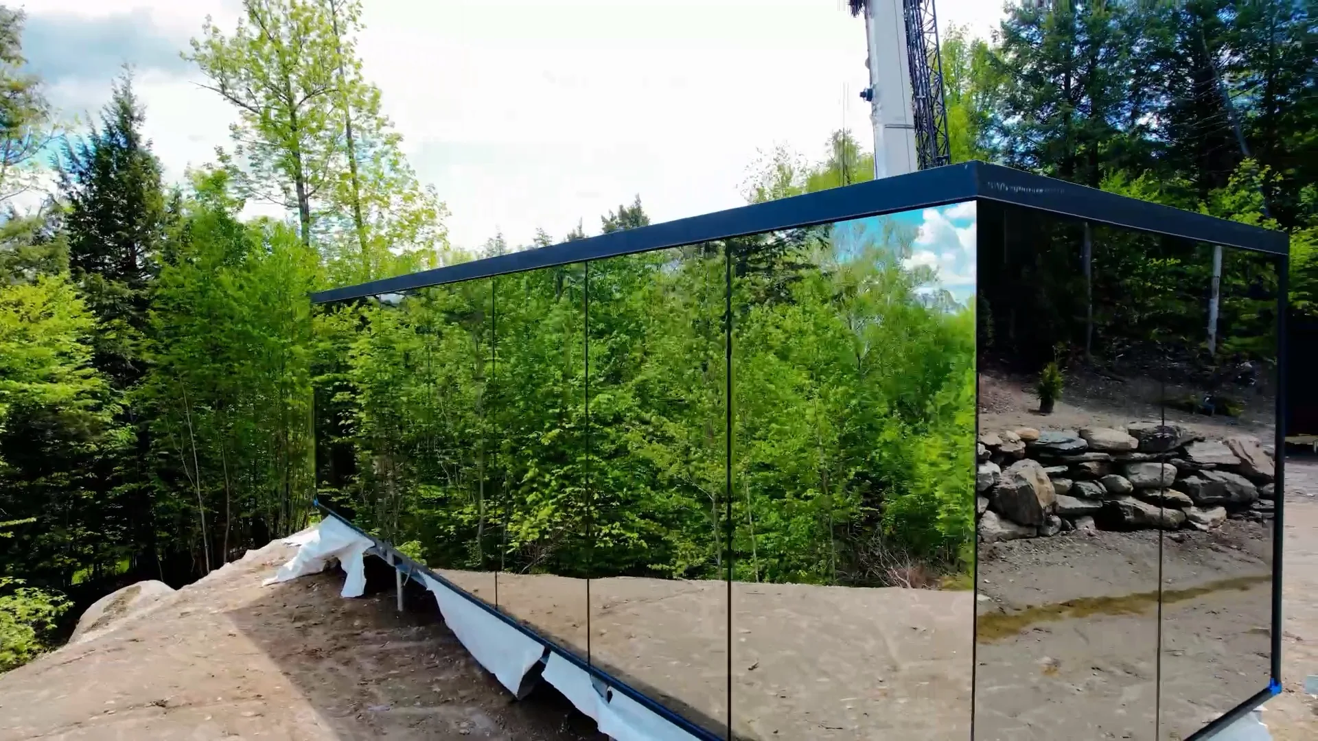 Mirror cabin facade with the delivery crane behind it