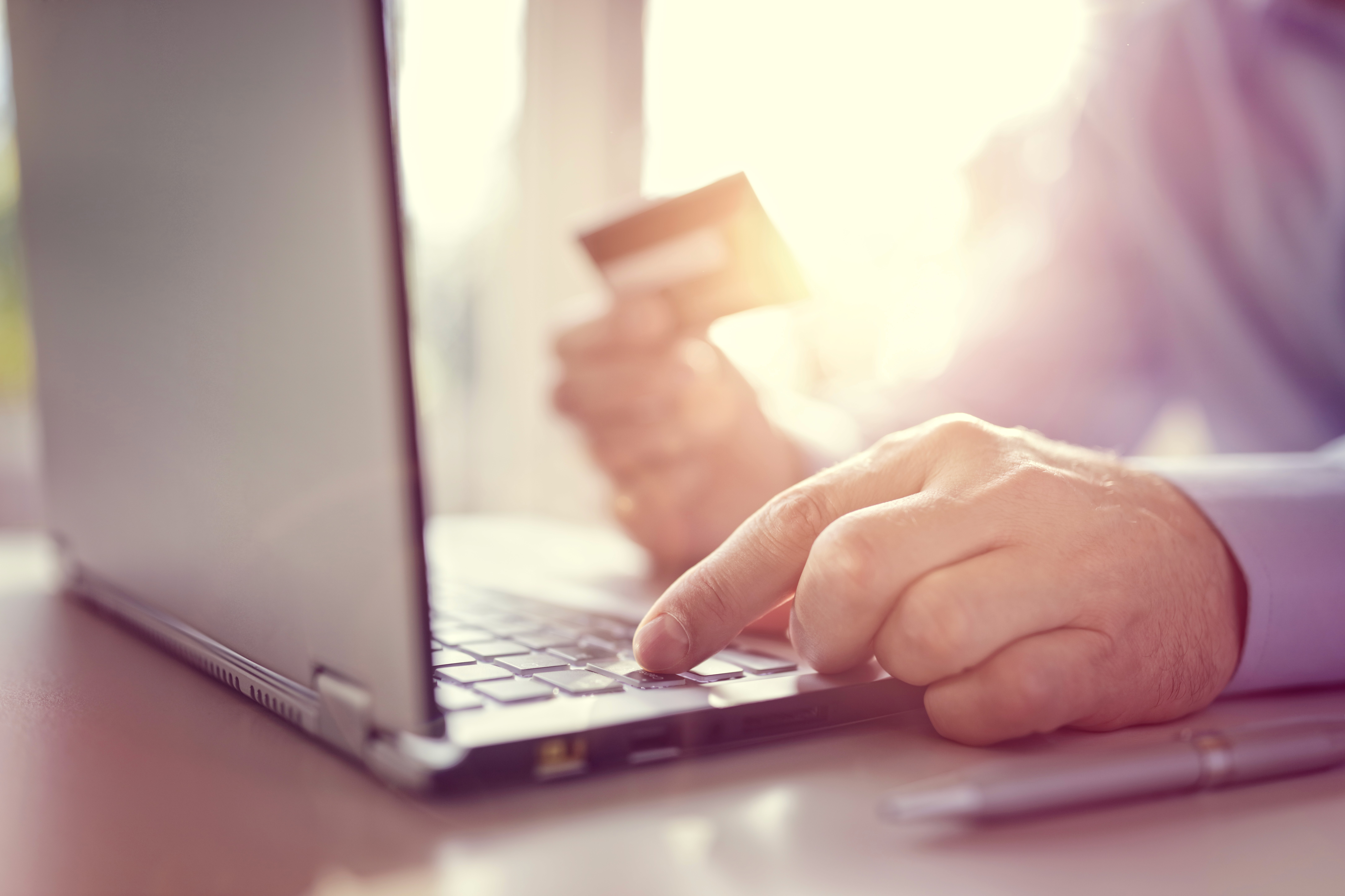 A person on a laptop with a credit card doing digital transactions