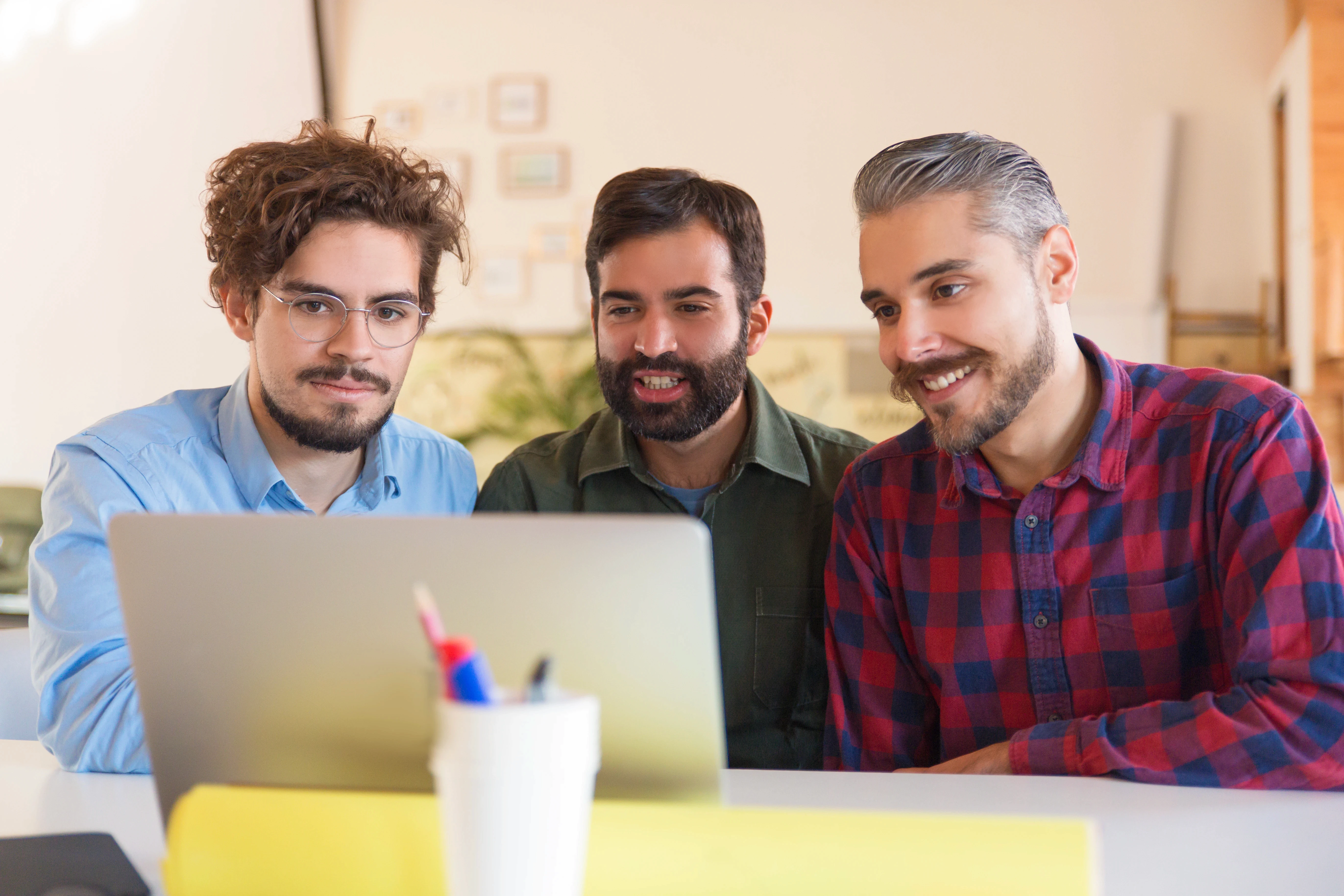 happy-startup-team-watching-presentation-monitor