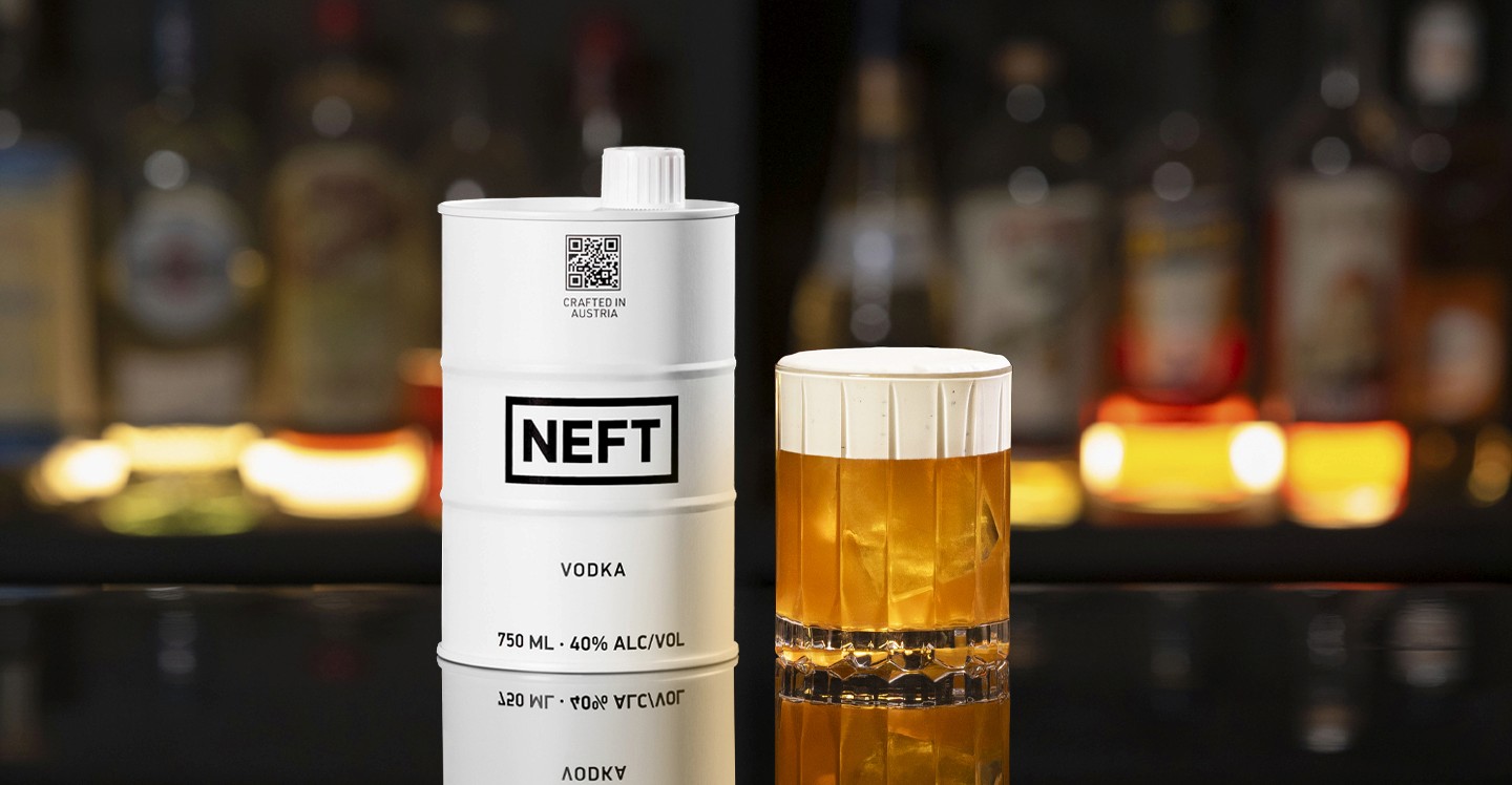A NEFT Barrel and a glass of Afternoon Tea Old Fashioned on a bar counter.