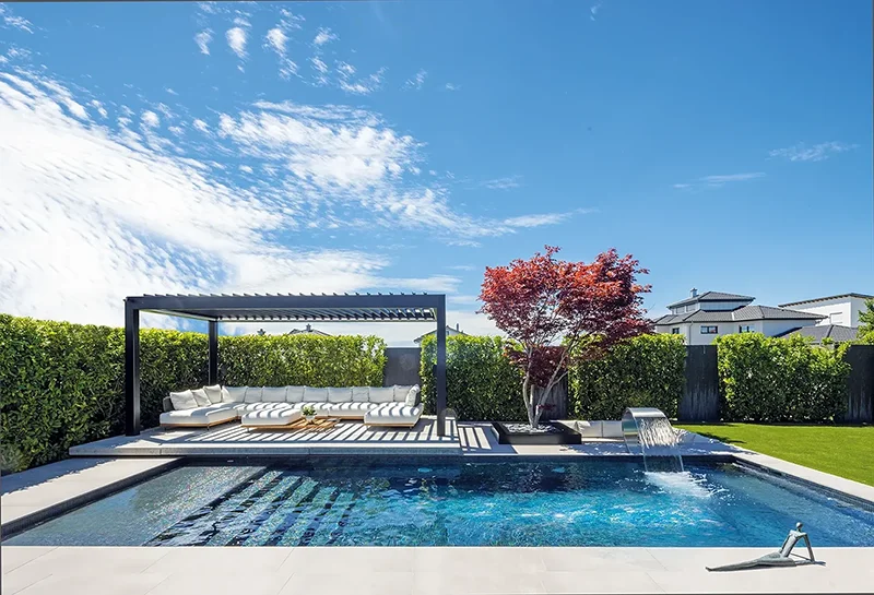 MLine Pool mit dunkler Pergola, Loungebereich und japanischem Ahorn