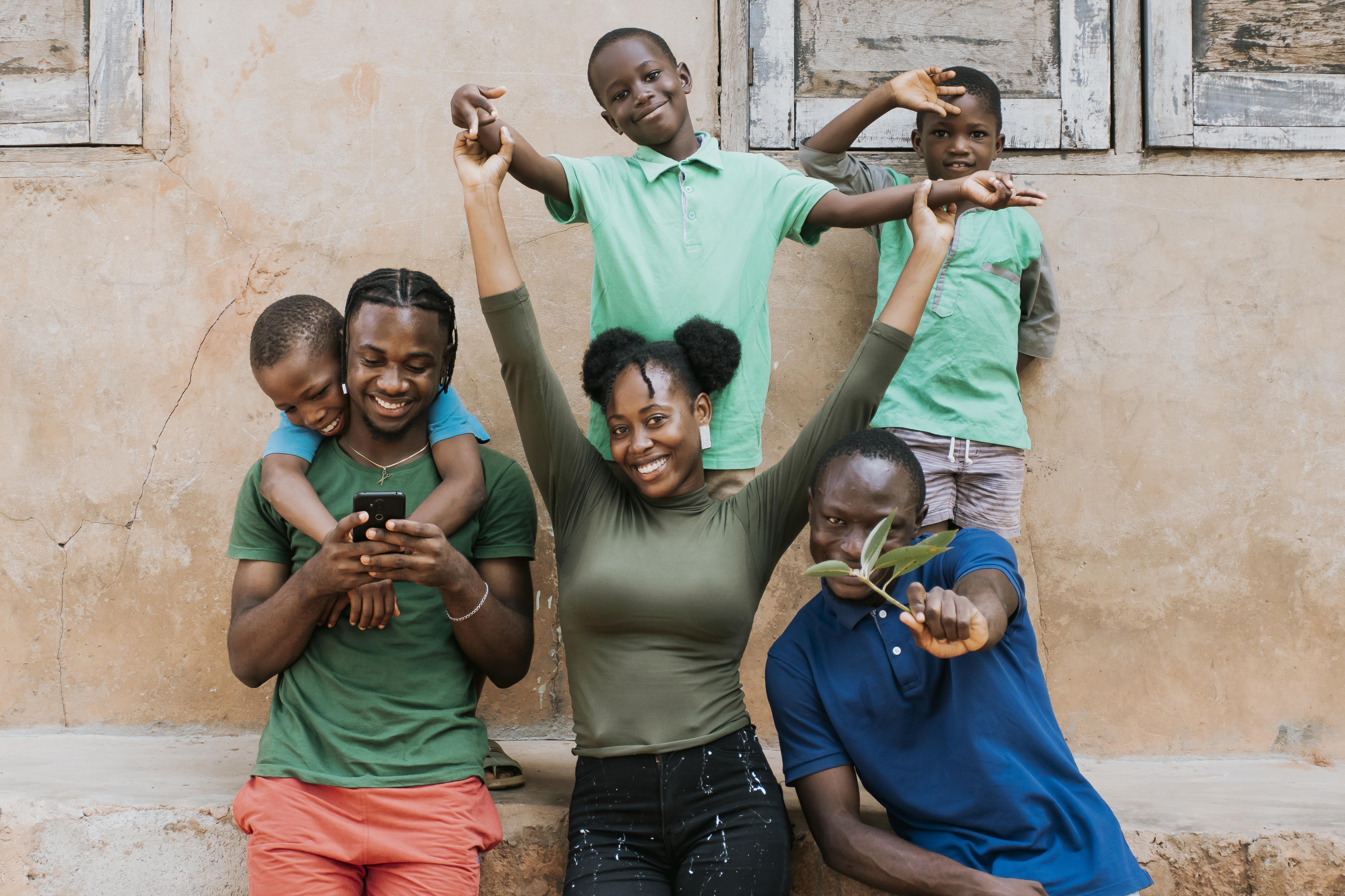 group of women in red and white dress standing on brown wooden bar during daytime