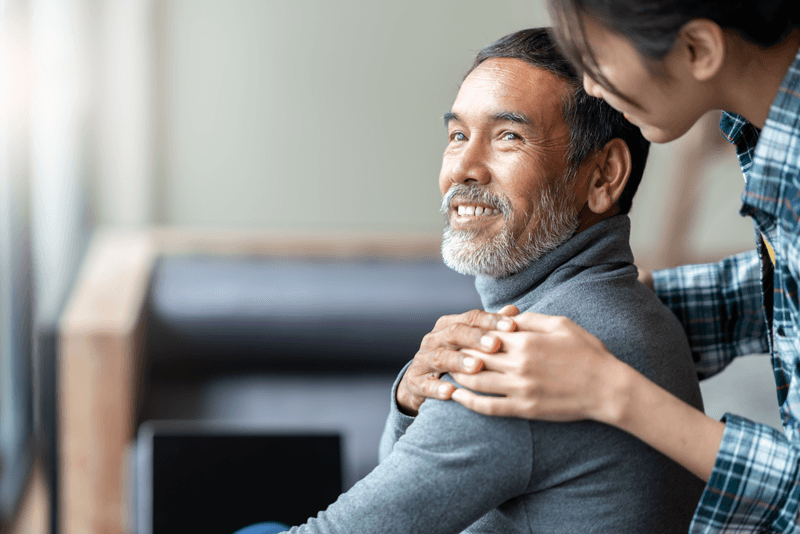 Caregiver touching a male in a wheelchair