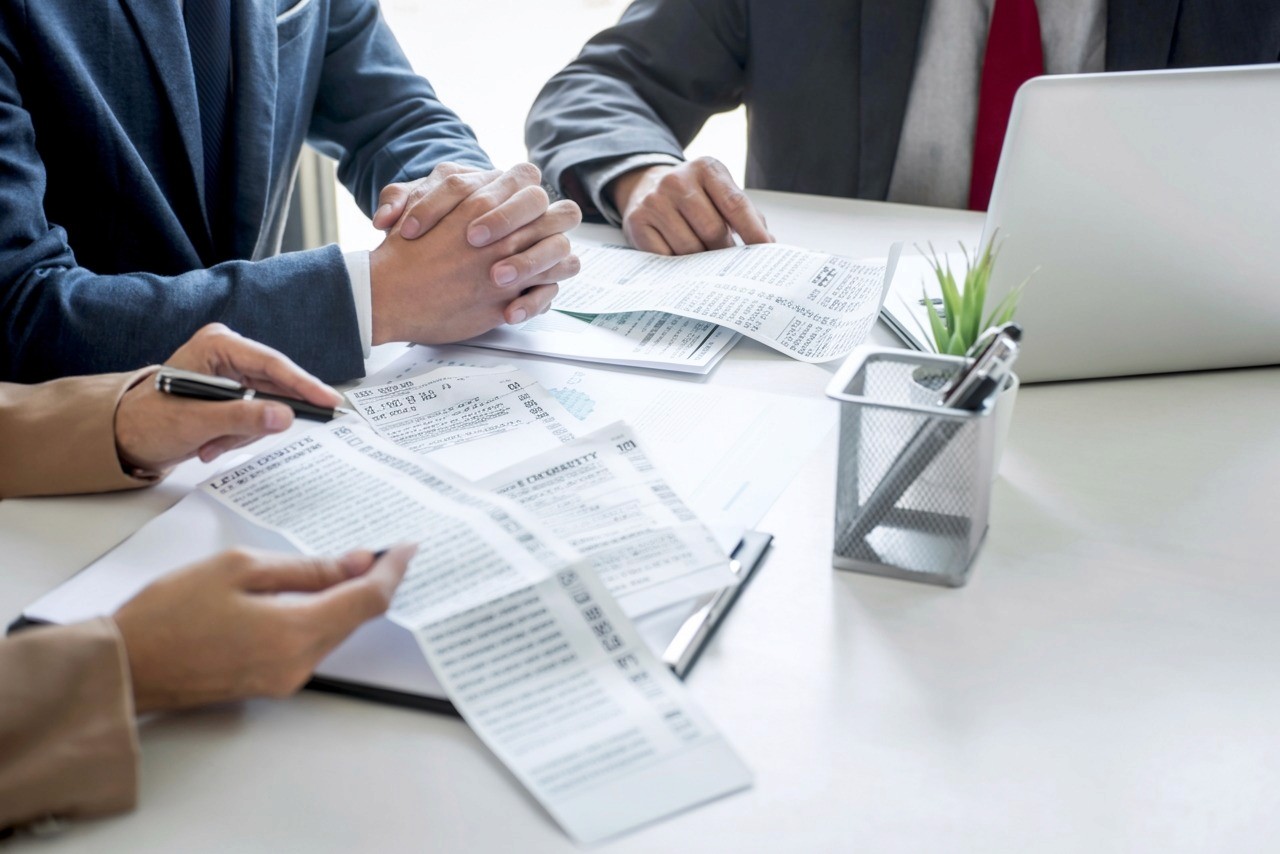 Riunione tra consulente fiscale e imprenditore per analizzare le novità del Dl Fisco 2025 con scontrini alla mano