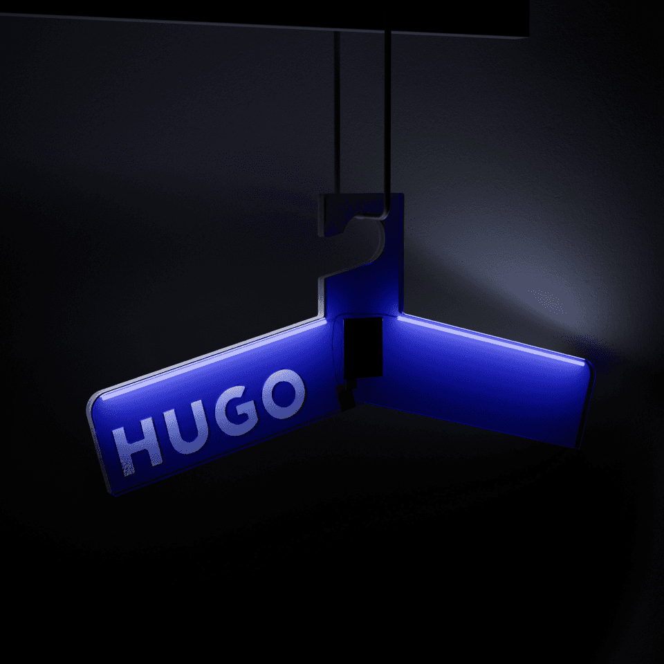 HUGO Brand Object – derselbe Acryl-Kleiderbügel inszeniert vor schwarzem Hintergrund, das Hugo-Blau leuchtet durch das transluzente Material.