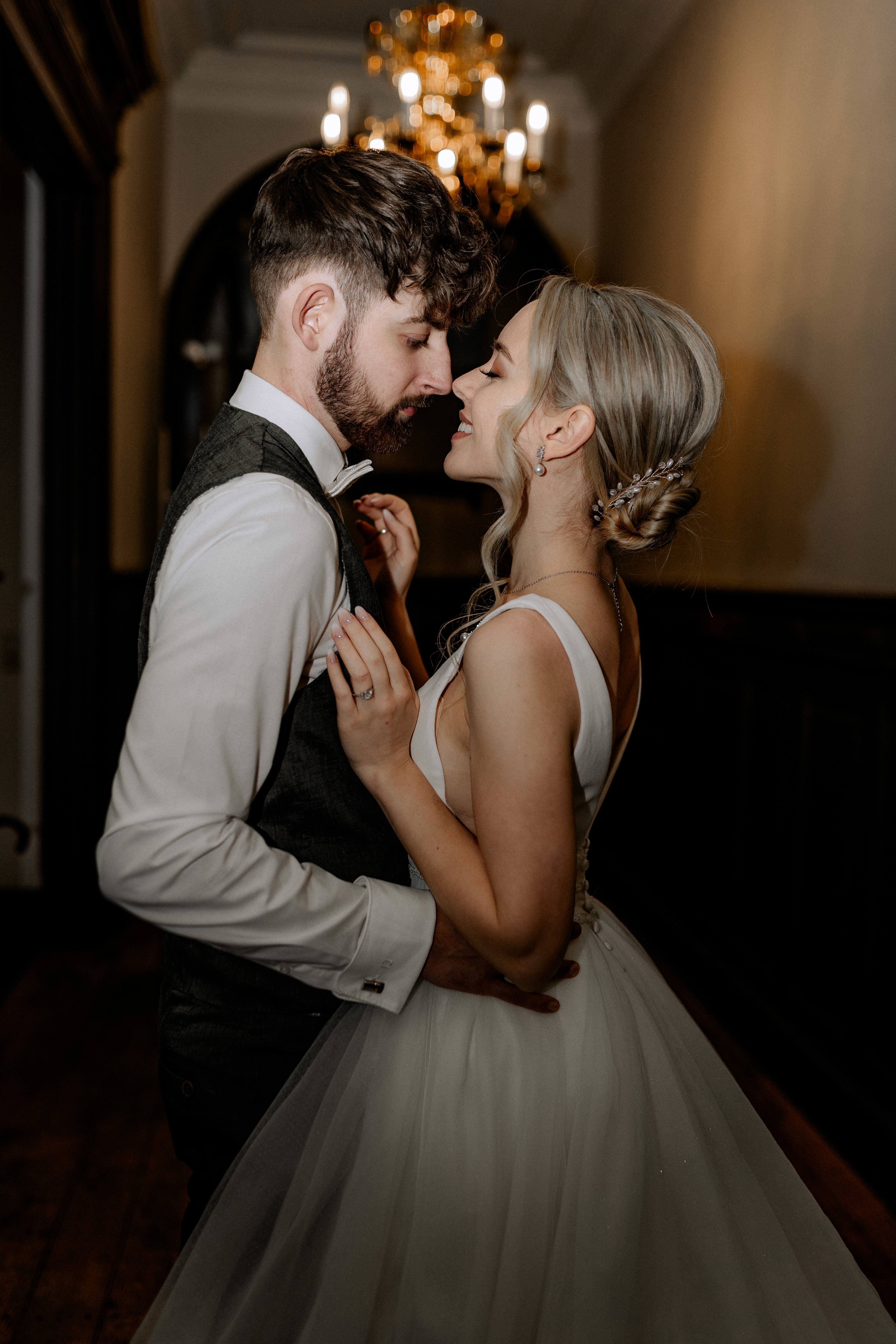 Brautpaar umarmt sich in eleganter Kleidung mit romantischem Blick