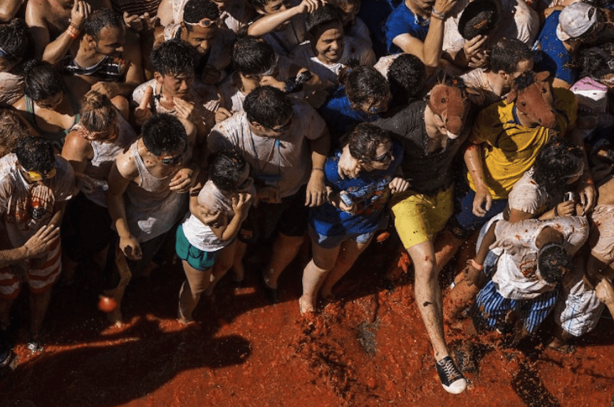 A large crowd of people standing in front of a tall building
