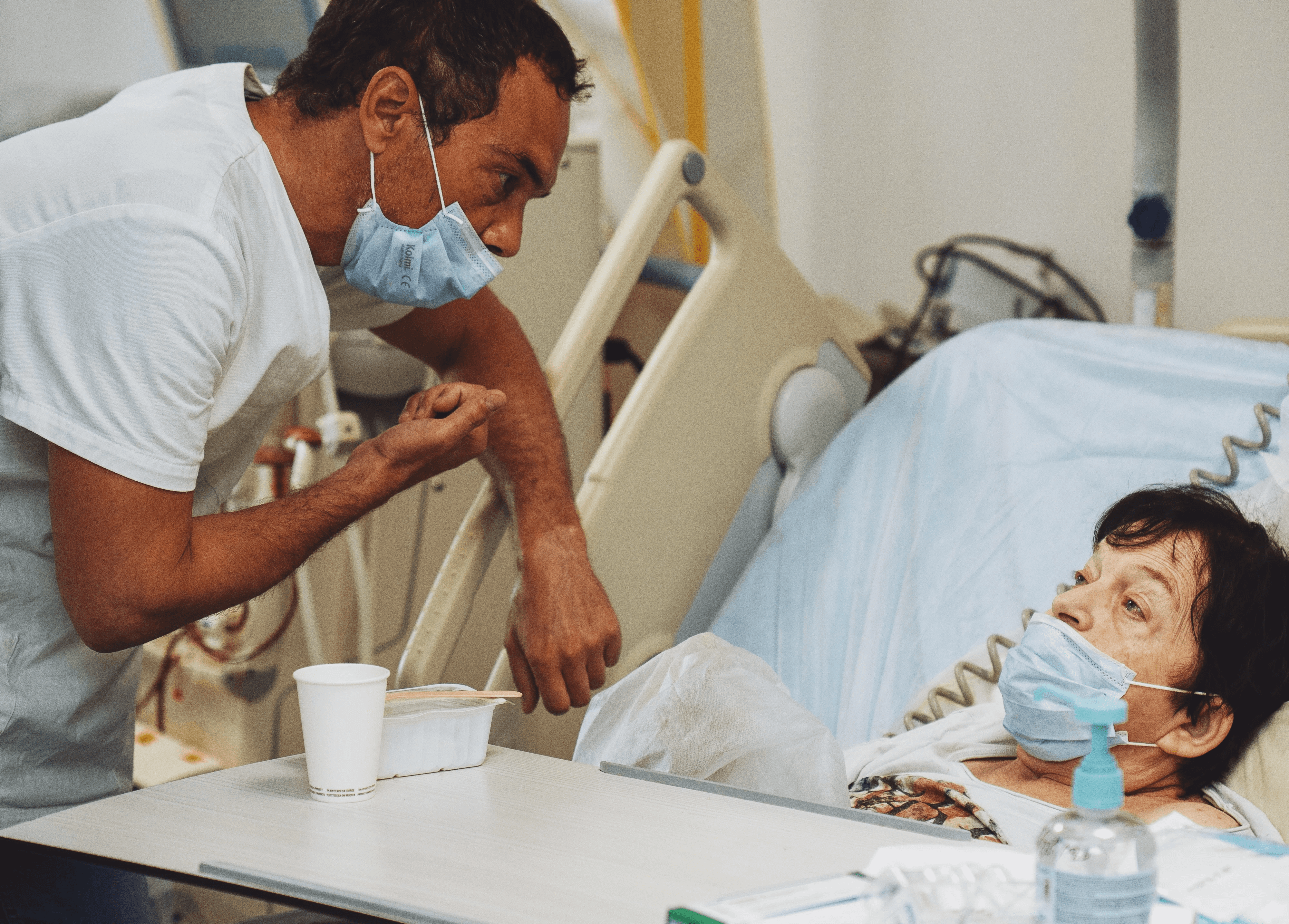Patiente en séance de dialyse allongée, accompagnée par un kinésithérapeute