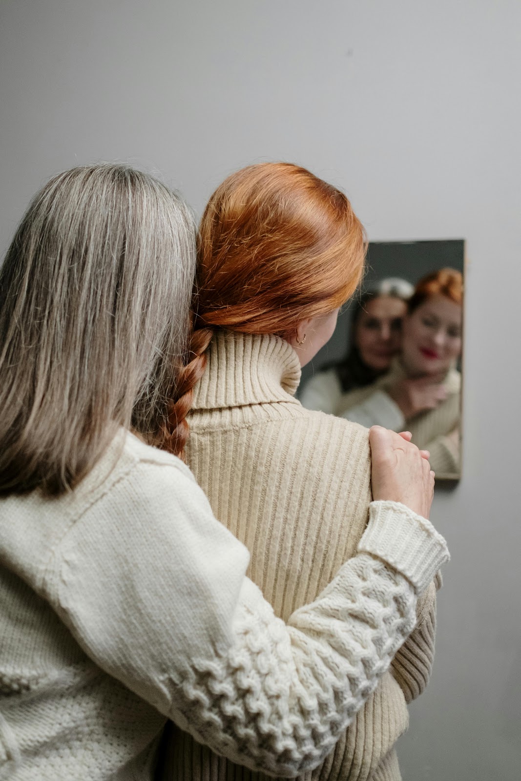 Conversion Truth for Families: Mother and teenage daughter embracing, looking at their reflections in a mirror