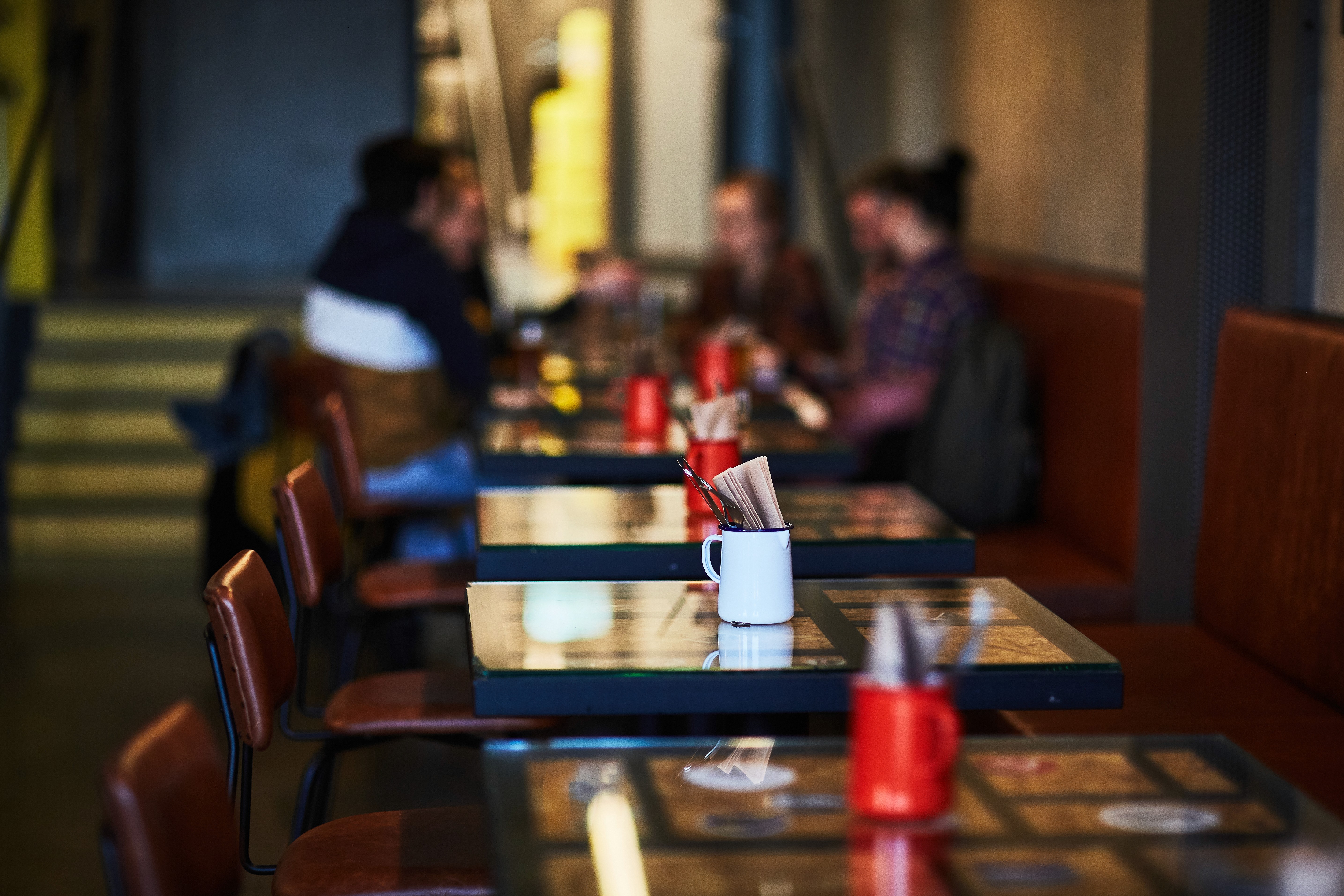 Dining area inside Le Kock restaurant at Exeter Hotel in Reykjavik with cozy booths, tables, and guests enjoying a meal.&nbsp;
